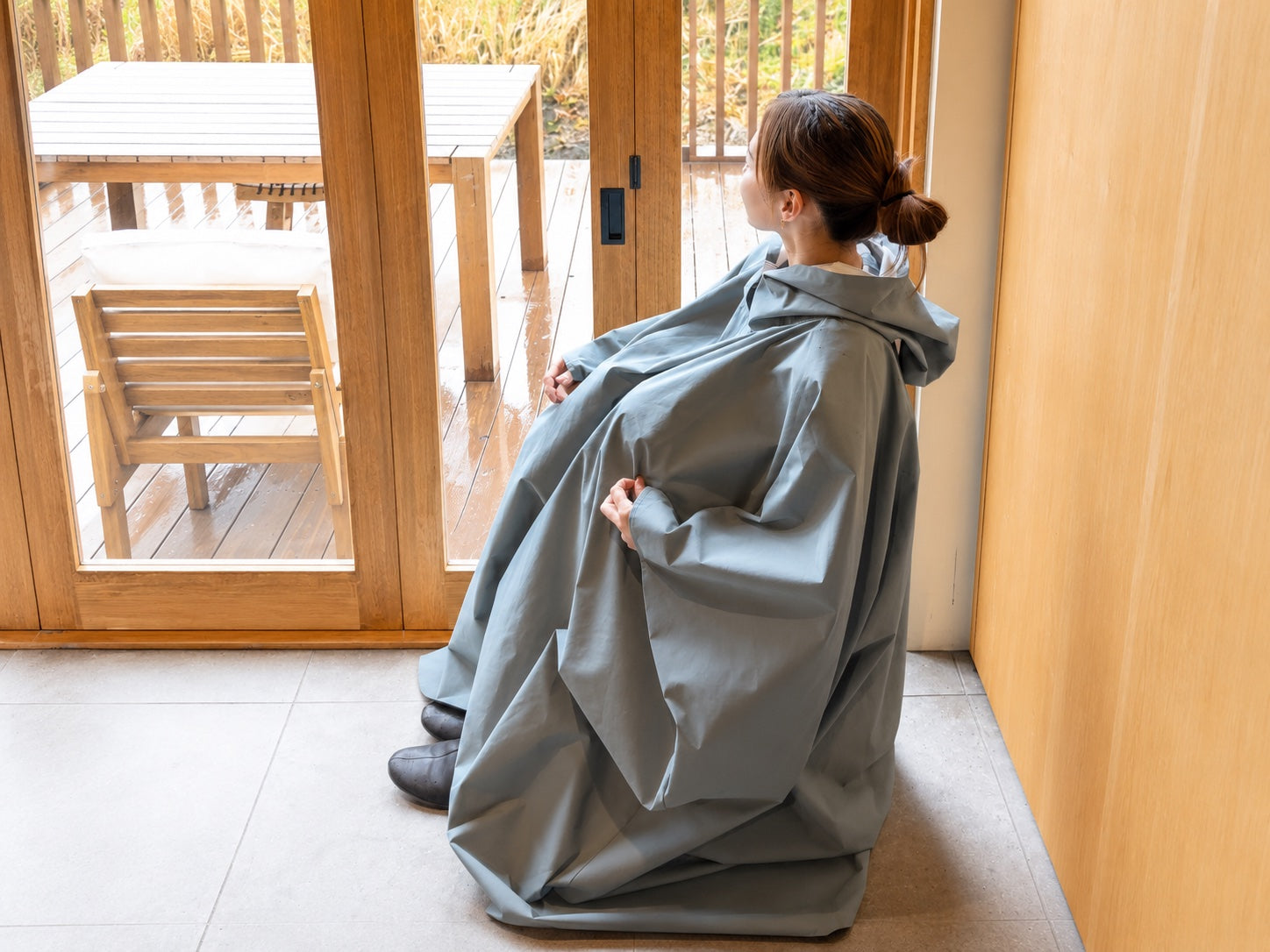 MUUSU のよもぎ蒸しマントを着用して座る女性